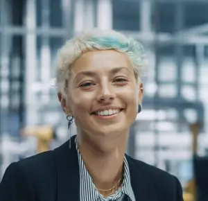 Eine lächelnde blonde Frau in einer Industriehalle
