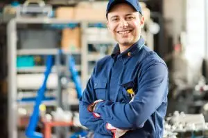 Glücklicher Mechaniker in blauer Uniform